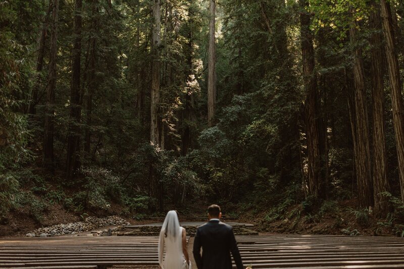 Bride and groom walking into the amphitheater in Armstrong Redwoods State Reserve during their all-day Northern California redwood elopement