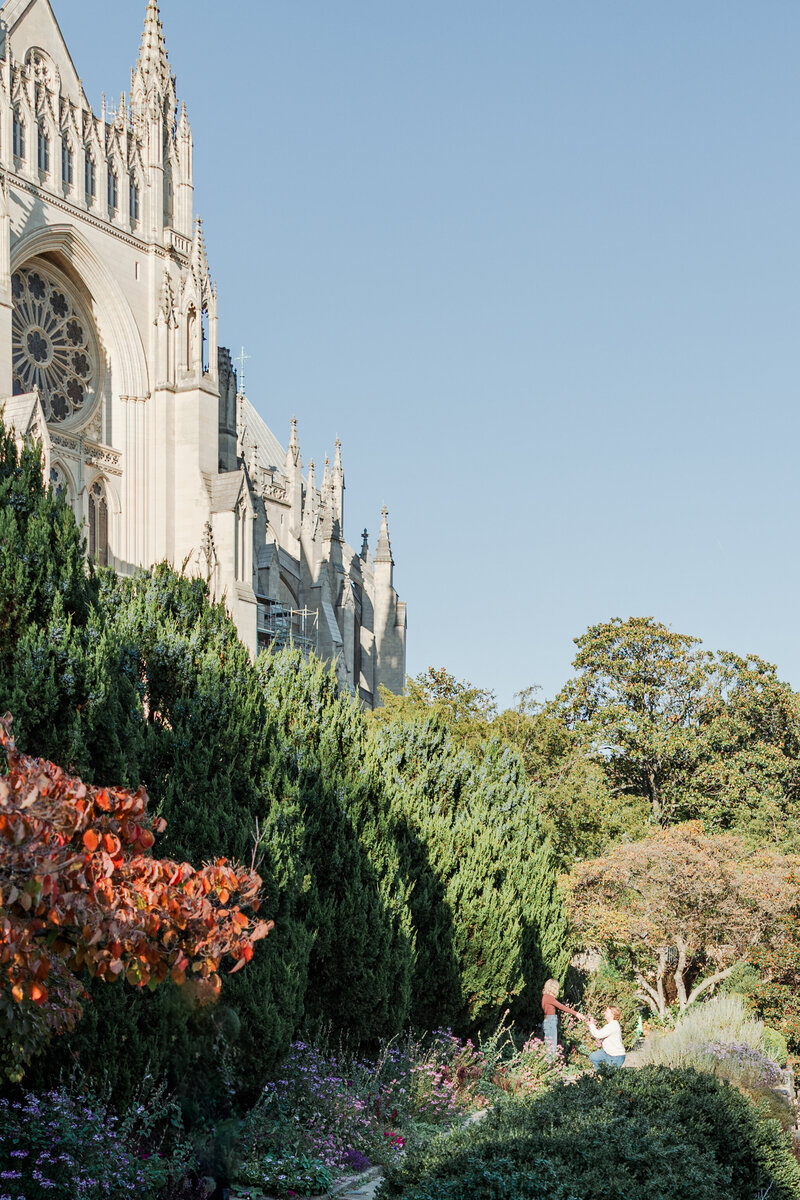 Atlanta Engagement Photographer | Engaged Couple proposing in a park next to a large Catholic church in Washington DC