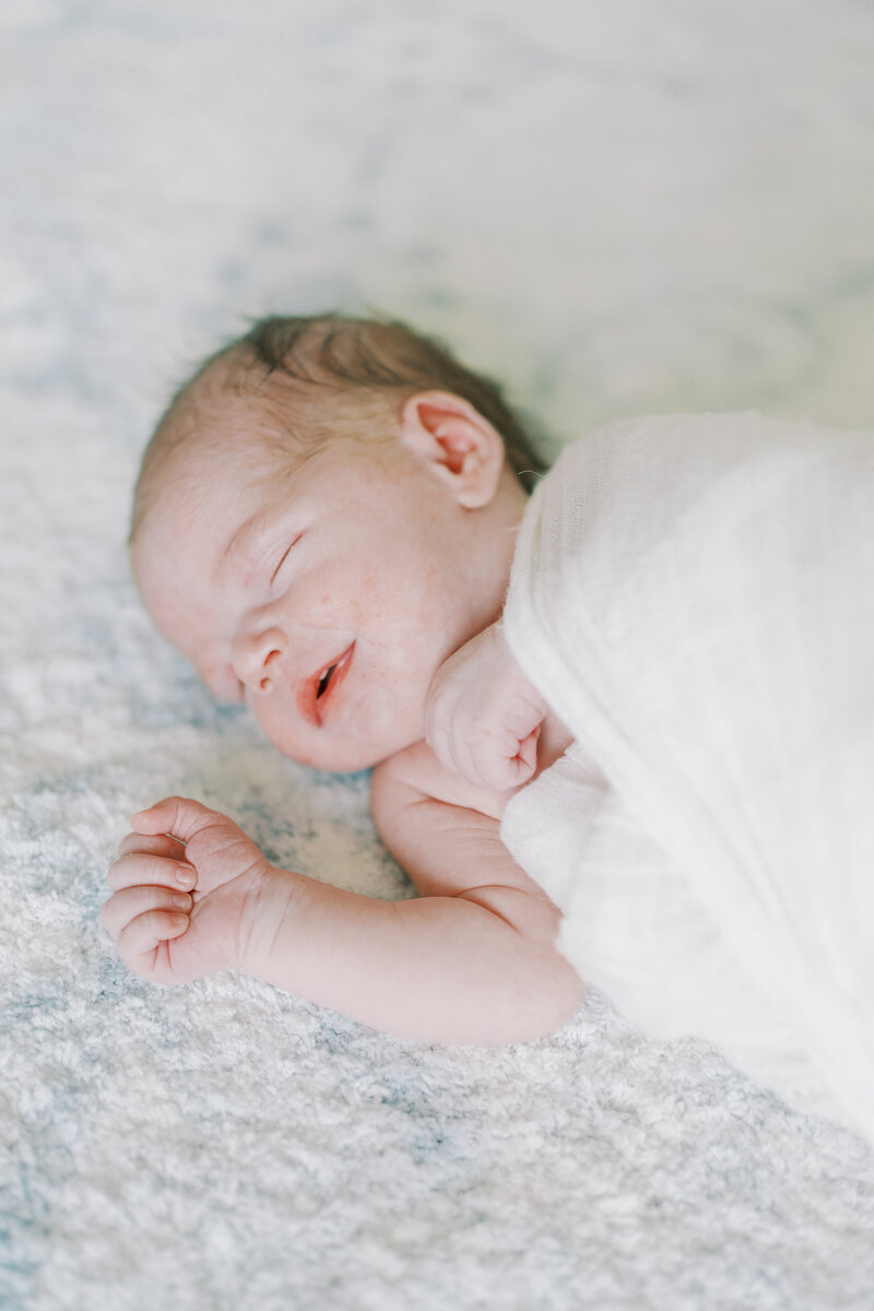 close up photo of newborn baby smiling 