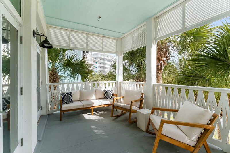 Relaxing balcony with plush lounge chairs overlooking Lake Carillon at The Florida House, steps from Carillon Beach, Santa Rosa Beach, and 30A rentals.