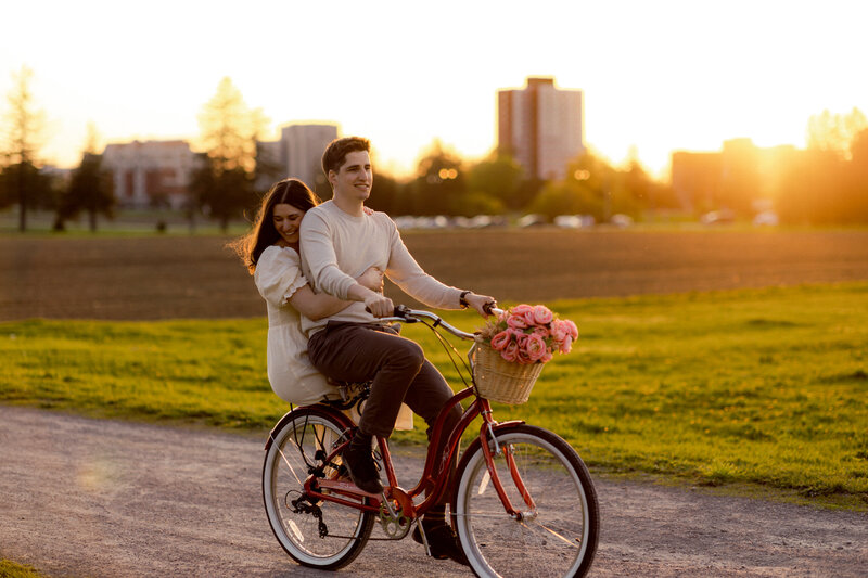 couple riding a bike during a sunset