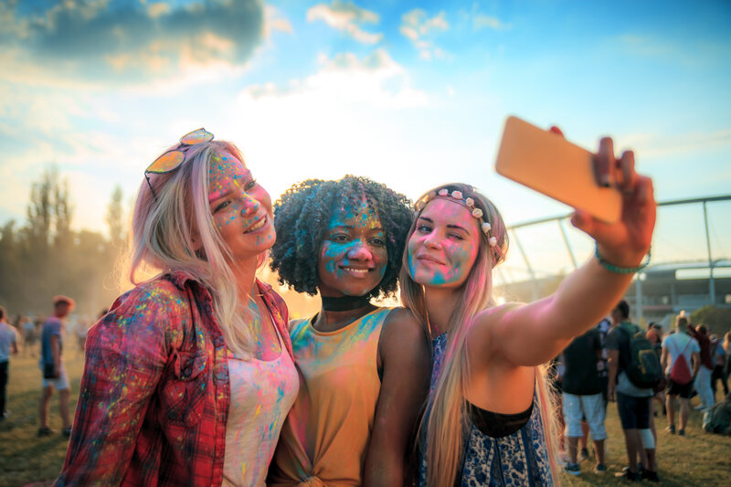 senior girls taking selfie of a paint photoshoot