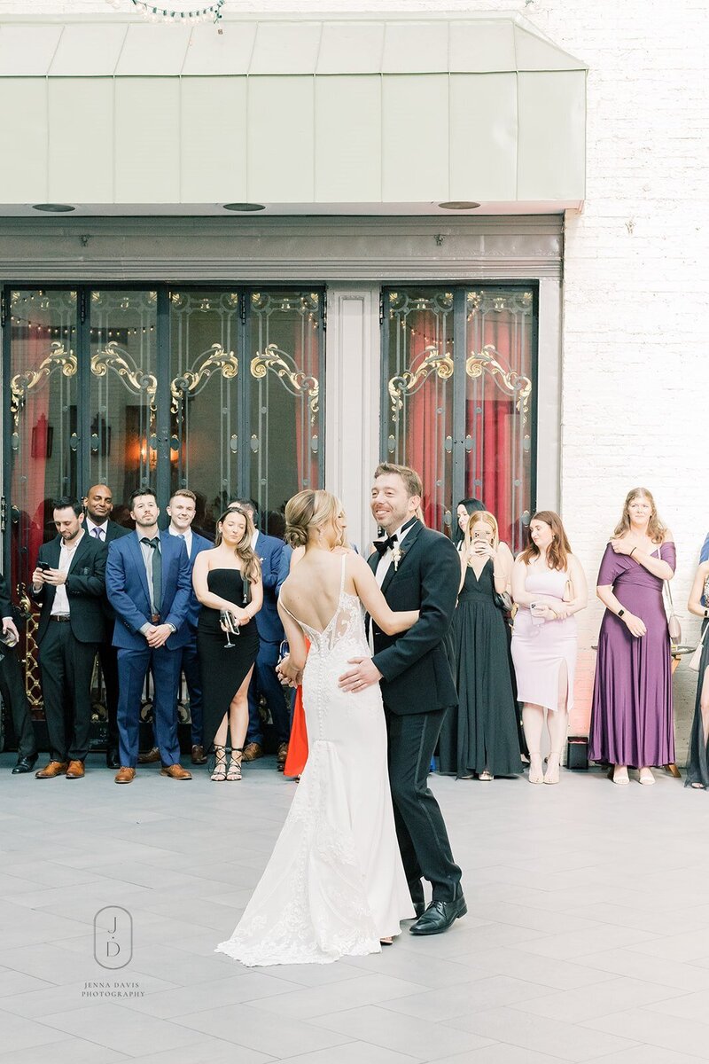 Bride and groom pose in front of the Baltimore skyline for their wedding portraits