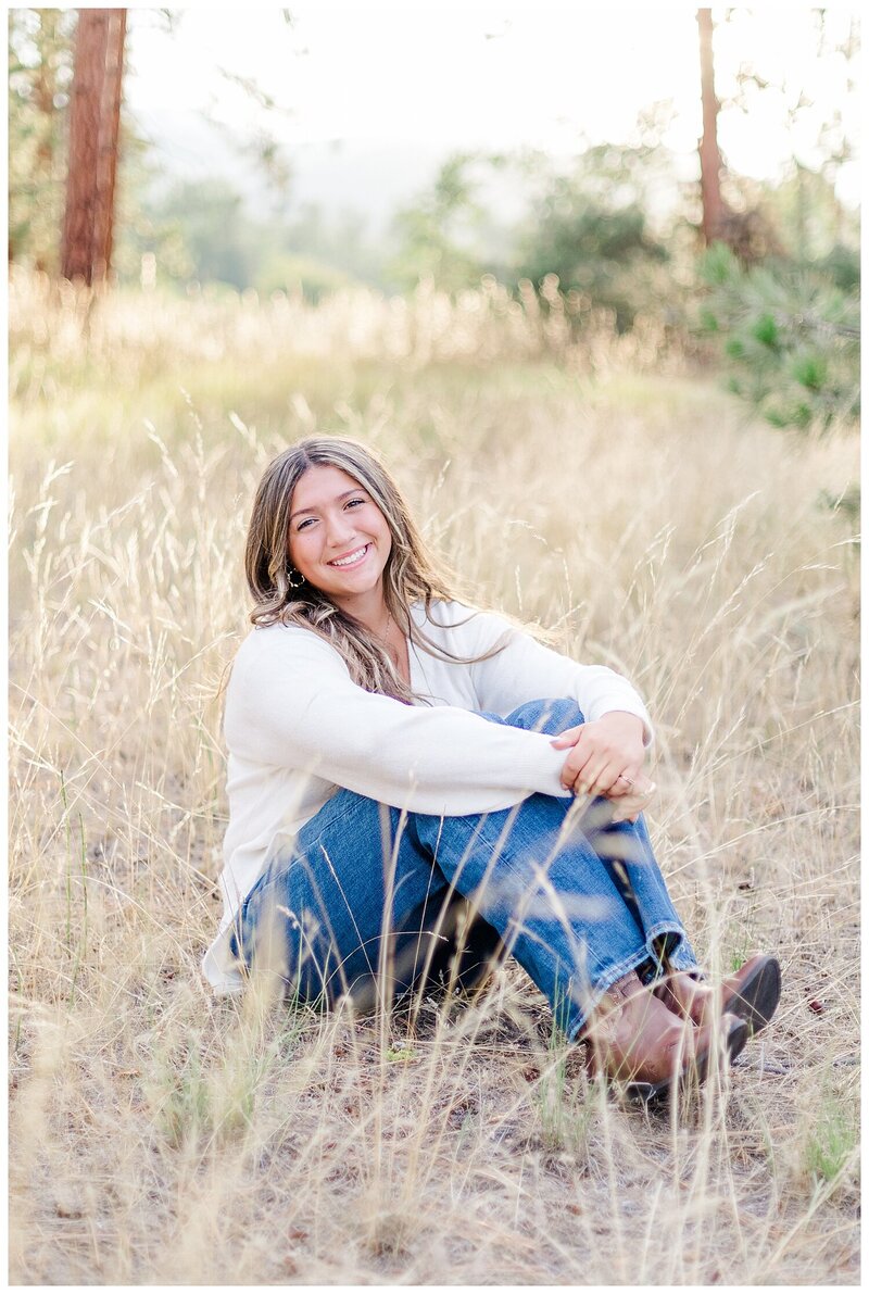high school senior sits in a field for Missoula senior photos
