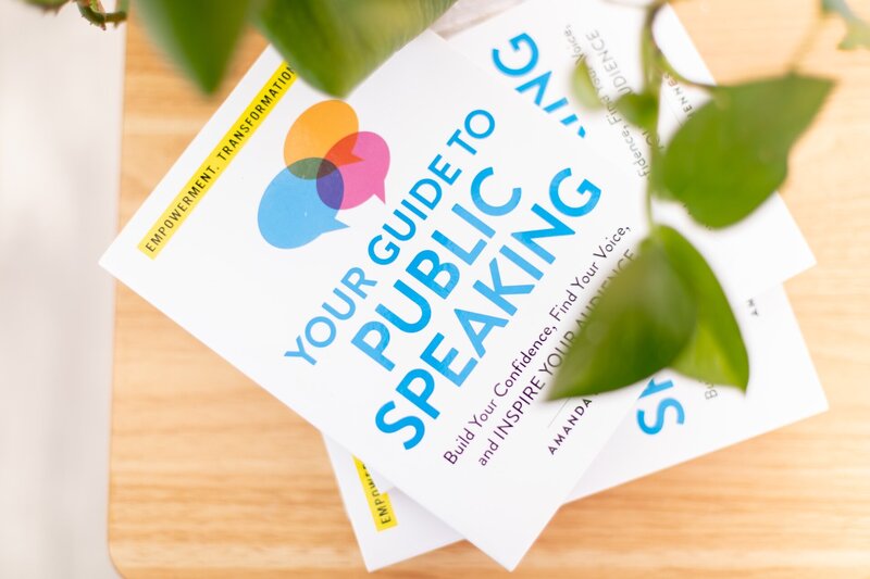 2 copies of Your Guide to Public Speaking by Amanda Hennessey on a desk
