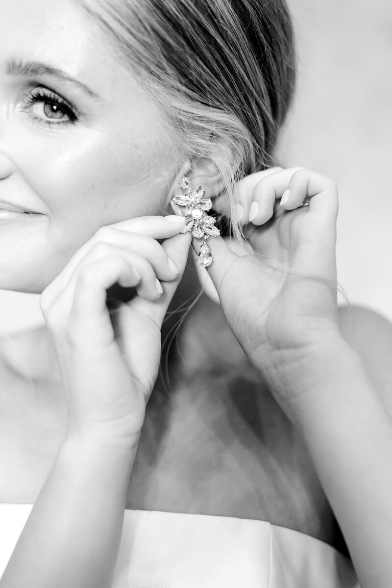 picture of bride putting on earring taken by Huntsville AL  Wedding Photographer Emily McIntyre Photography