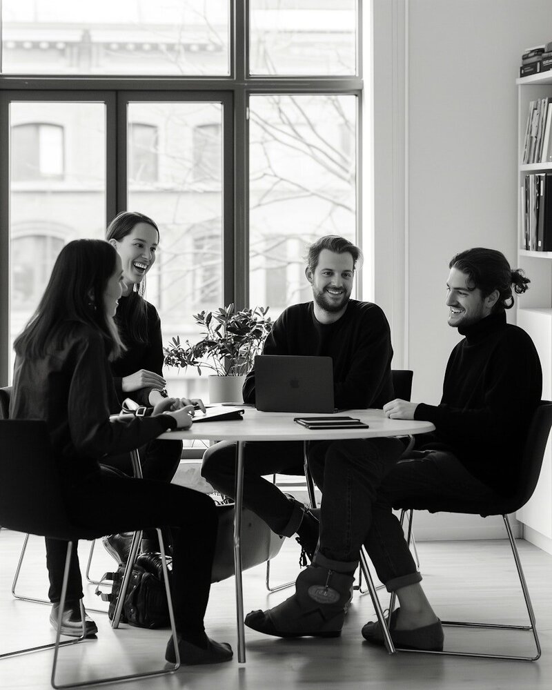 Smiling team of 4 sitting around a table