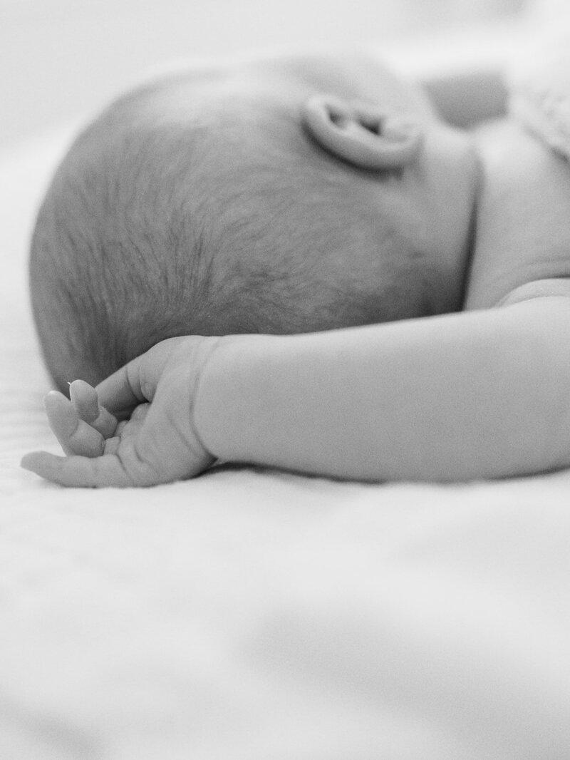 A close-up of a baby's arm and backside of the head at a newborn photography session in Richmond by Katie Stansfield Photography.