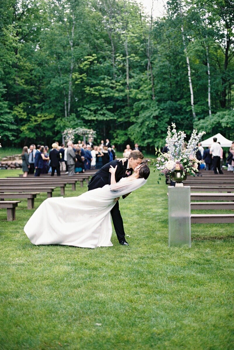 Bride and groom sharing their first kiss as a married couple after exchanging vows, captured by Milwaukee wedding photographer Emily Barbara.