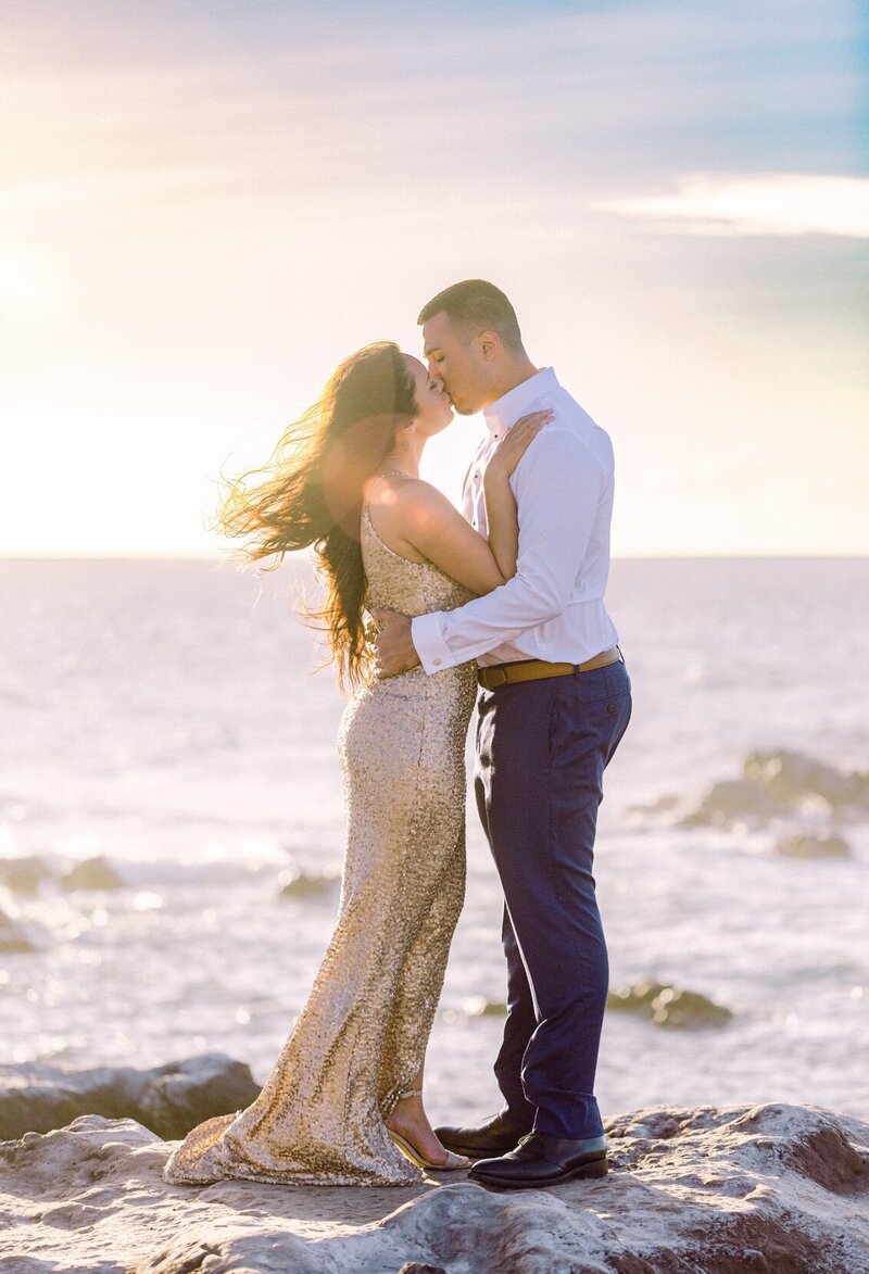 Golden light sunset engagement portrait with long gown by the blue ocean cliffs on Maui