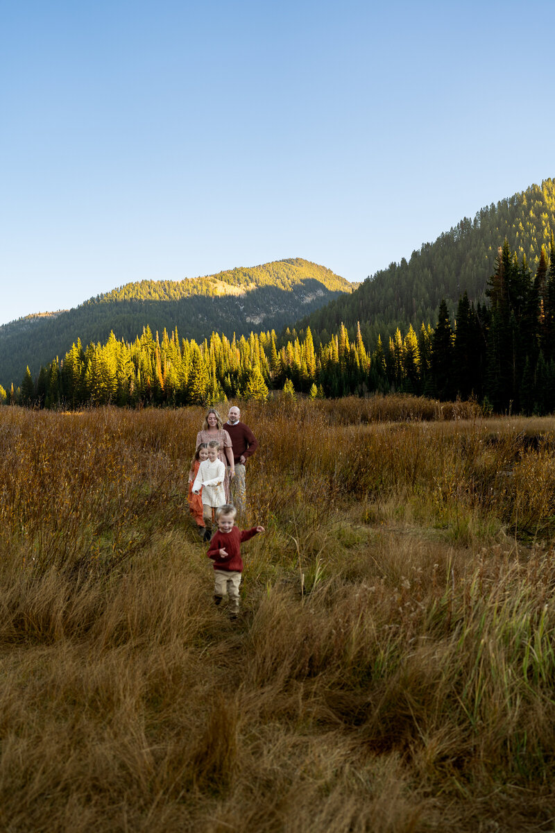 Family walking through field in the mountains of Salt Lake City, Utah