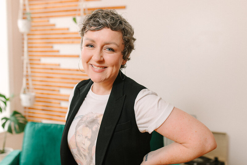 Danielle smiles into the camera in the lobby of Holly Michigan's Boho Aesthetics lash bar and skin studio.