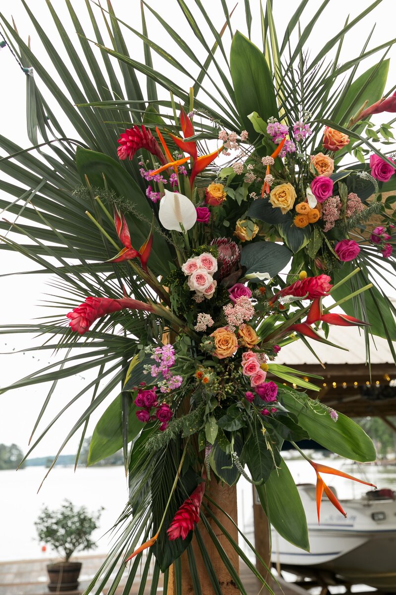 Palm tree floral arrangement with red, white, and orange flowers