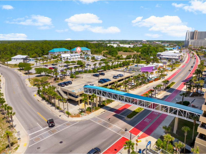 Aerial view of the Panama City Beach pedestrian overpass and parking area, showing the short walk to Welcome to Paradise and beach access.