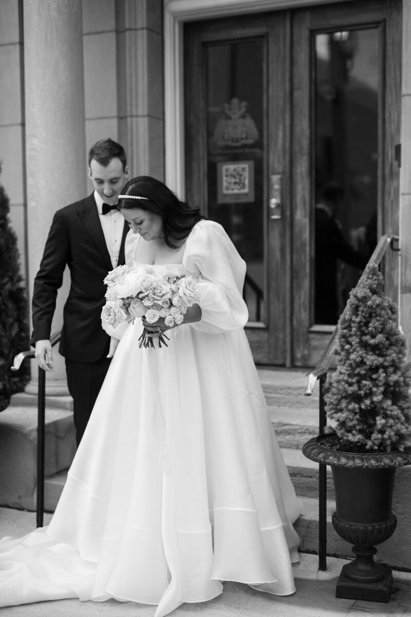 black and white photo of bride and groom  in front of the university club ot toronto