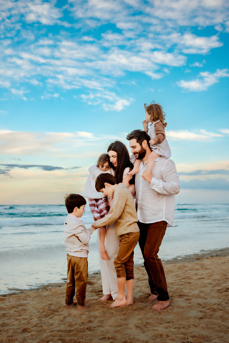 Captured in the heart of Brisbane's lush parklands, this family photo by Paula Jane Photography radiates joy and togetherness. Surrounded by the vibrant greenery of Roma St Parklands, the family shares laughter and embraces.