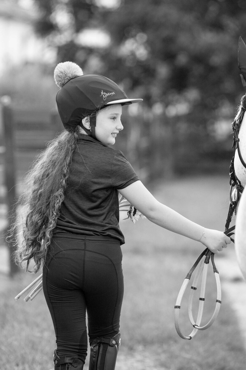kissimmee florida equine photography of girl walking next to her horse in a black and white photo