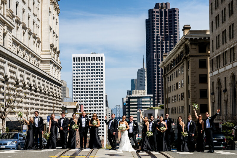 California Street San Francisco wedding photography featuring large bridal party against downtown architecture and Bay Bridge