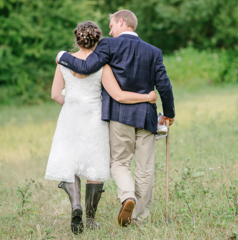couple walking in the long grass at wedding in oxford