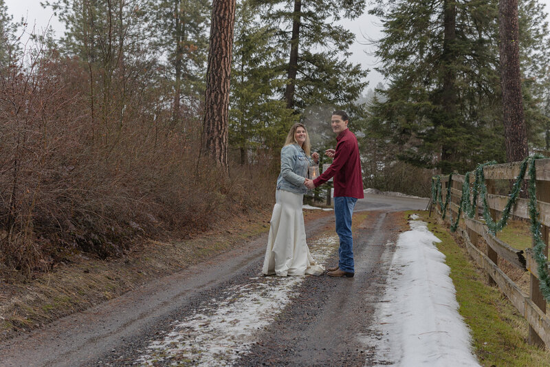 Couple walking down trail lookin back holding lanterns
