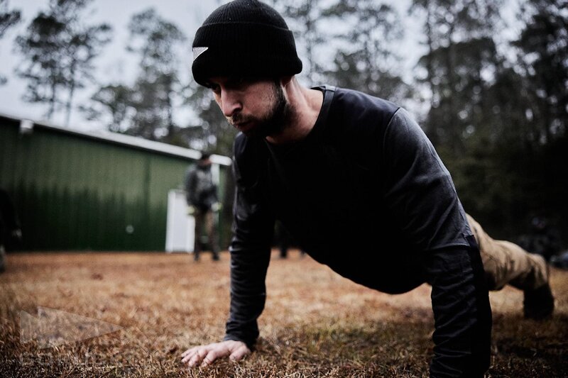 Joe Baker of Joe Baker Fitness performing push-ups during ruck training event for endurance and strength.