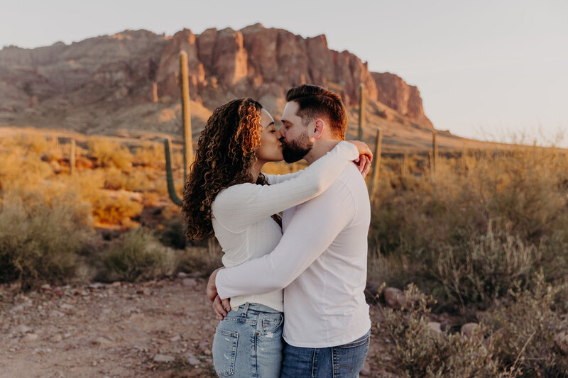 couple kiss in the soft glow of sunset in the desert
