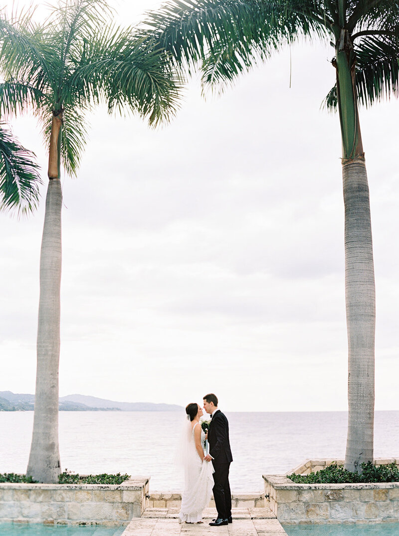 Bride and groom holding hands under palm trees – Destination Wedding Photographer Seattle DC California in Jamaica 