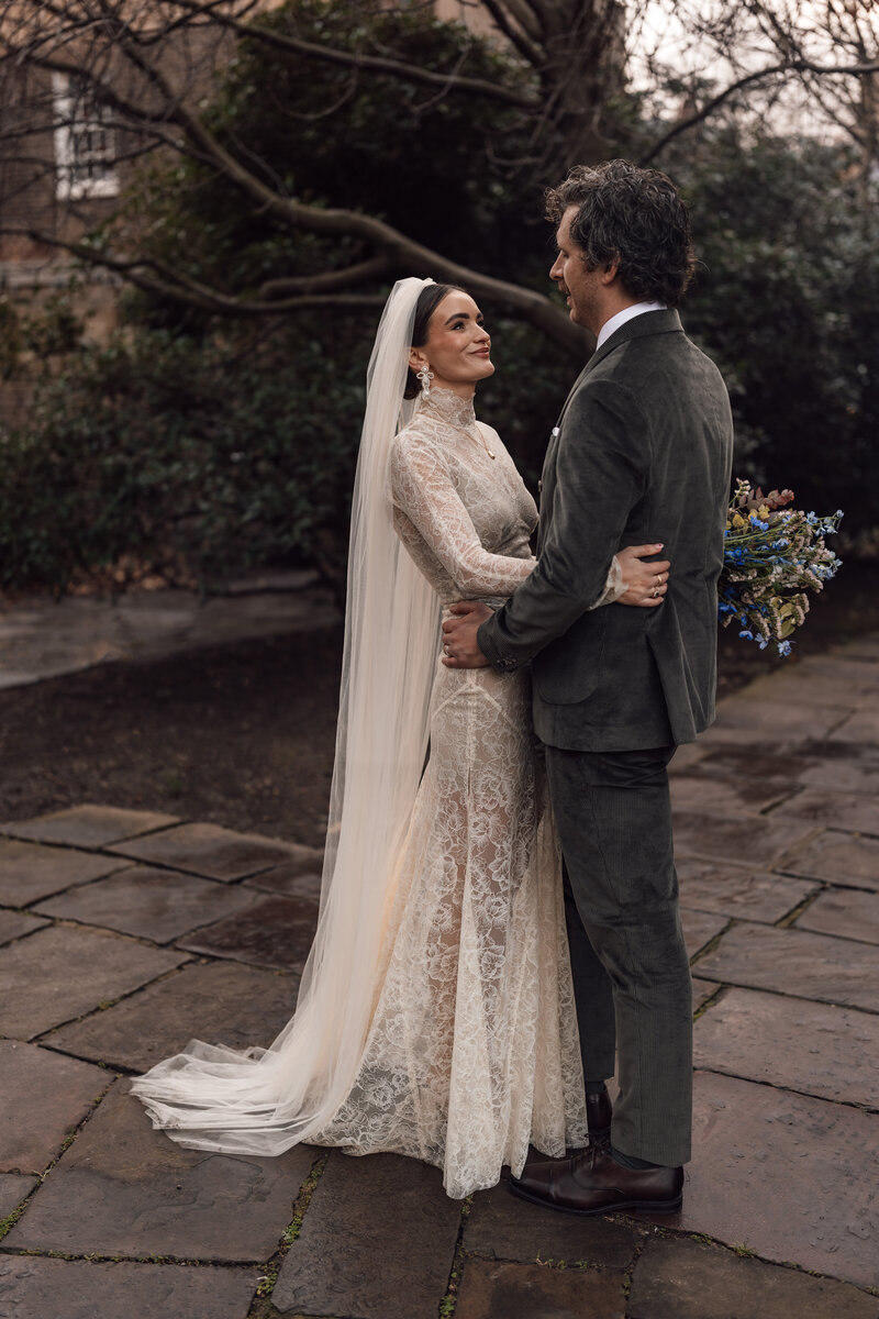 couple embrace in the streets of central london after finishing their ceremony at st etheldredas chuch