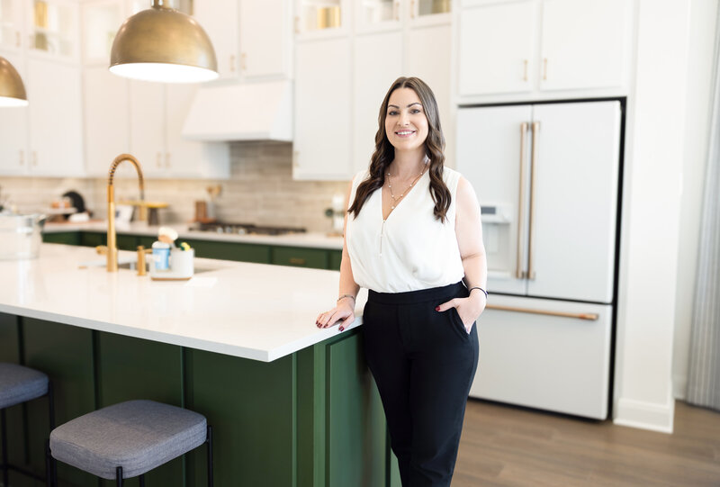 a realtor smiling while standing in the beautiful kitchen of a home