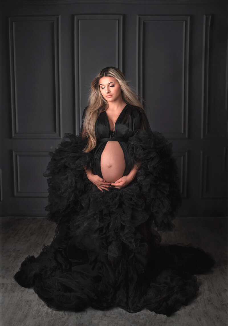 "Pregnant mom in a sophisticated black maternity gown, captured in a timeless and elegant studio maternity photography session in Ottawa."