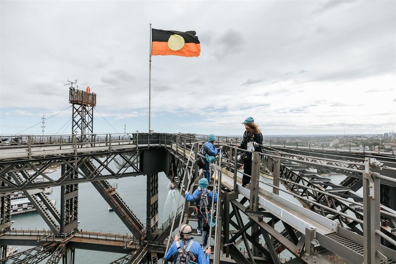 The aboriginal australian flag flying at th top of sydney harbour bridge.