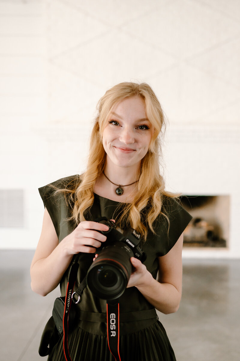 Julia smiling and holding a camera