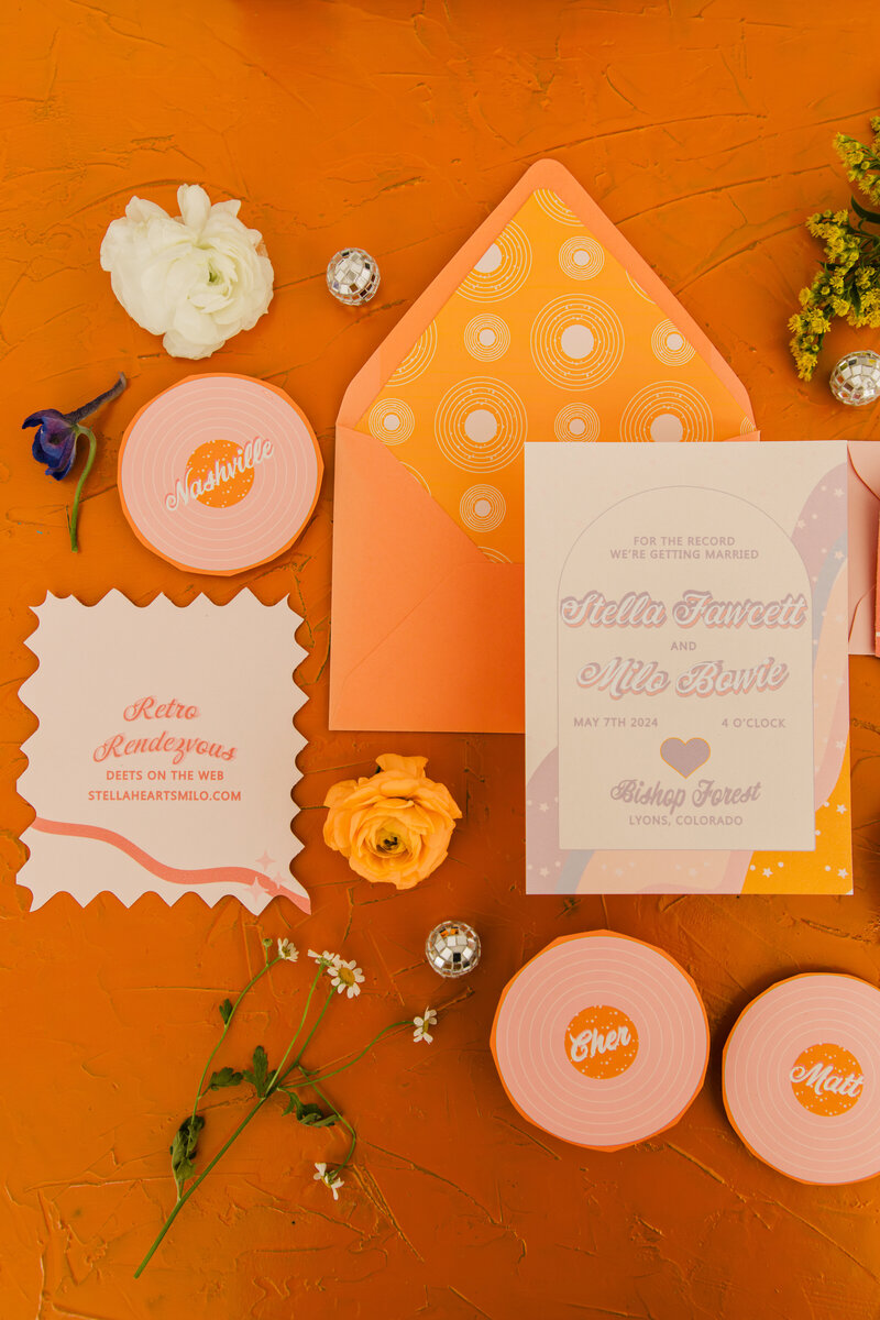 A retro themed wedding invitation suite with record place cards.