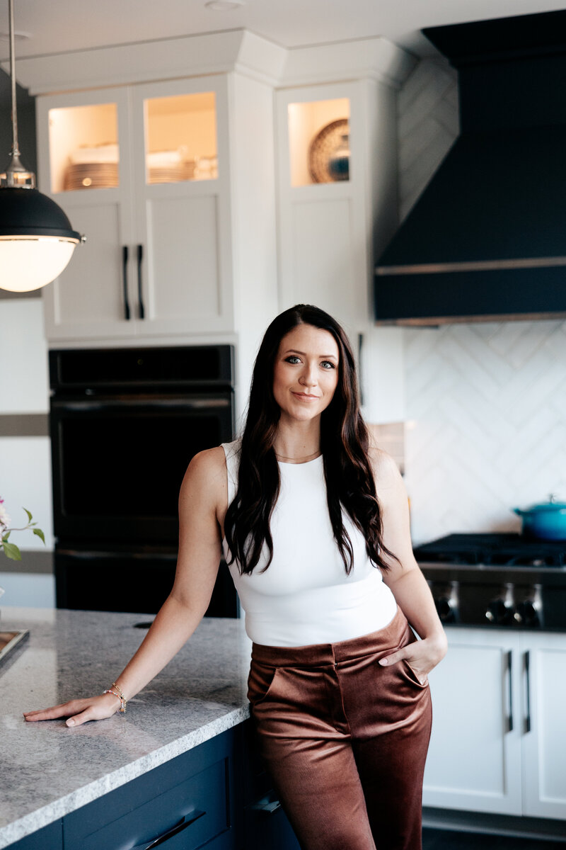 Closer view of woman leaning against the island in a kitchen