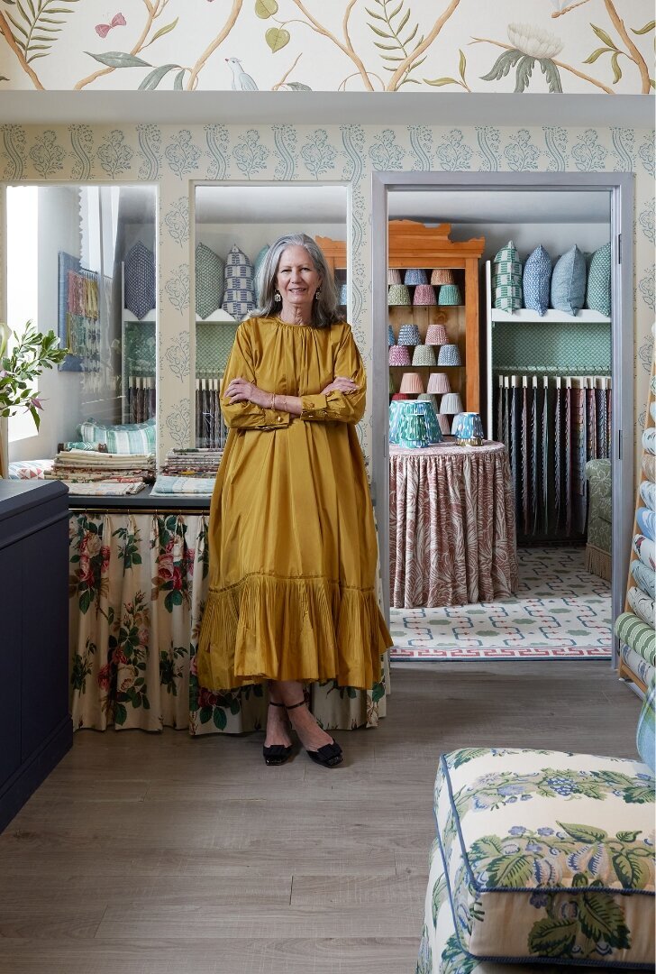 Kate Evans of Evans & Sheldon standing in the Evans & Sheldon trade room. She is wearing a flowy yellow dress.