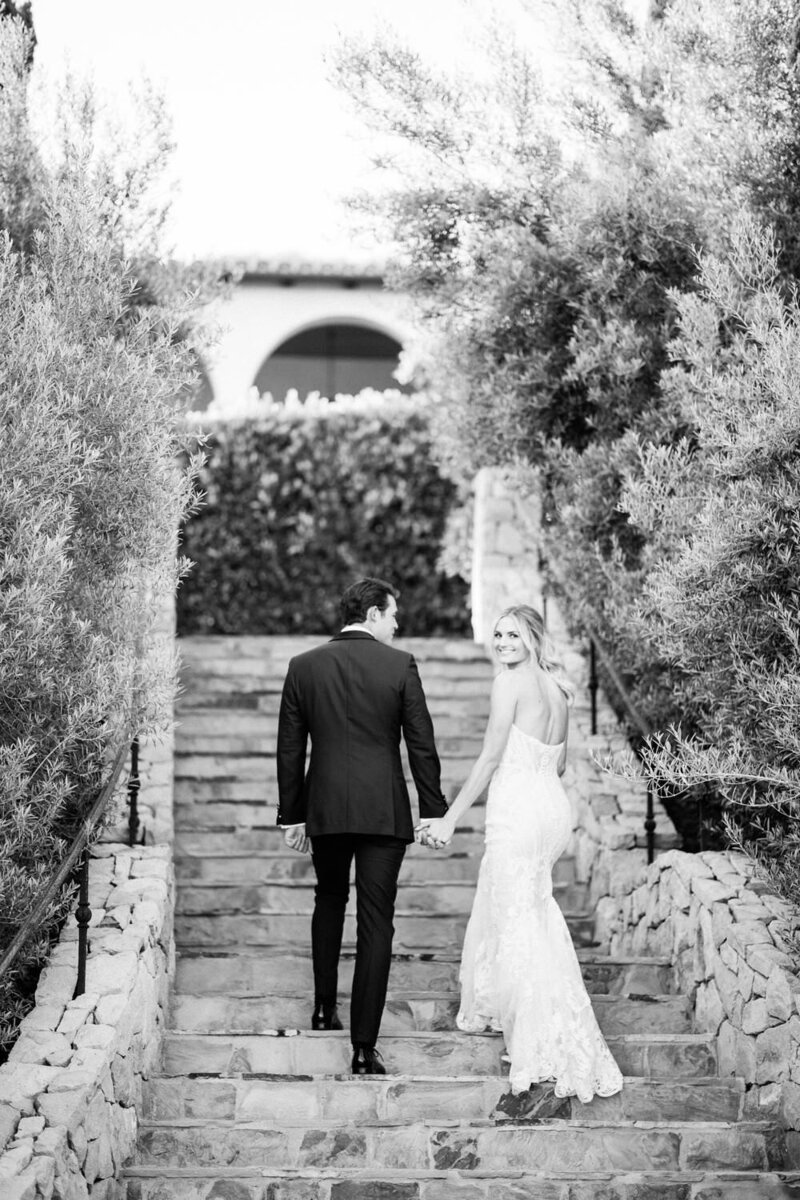 Bride and groom walk up stone steps at Klentner Ranch wedding venue
