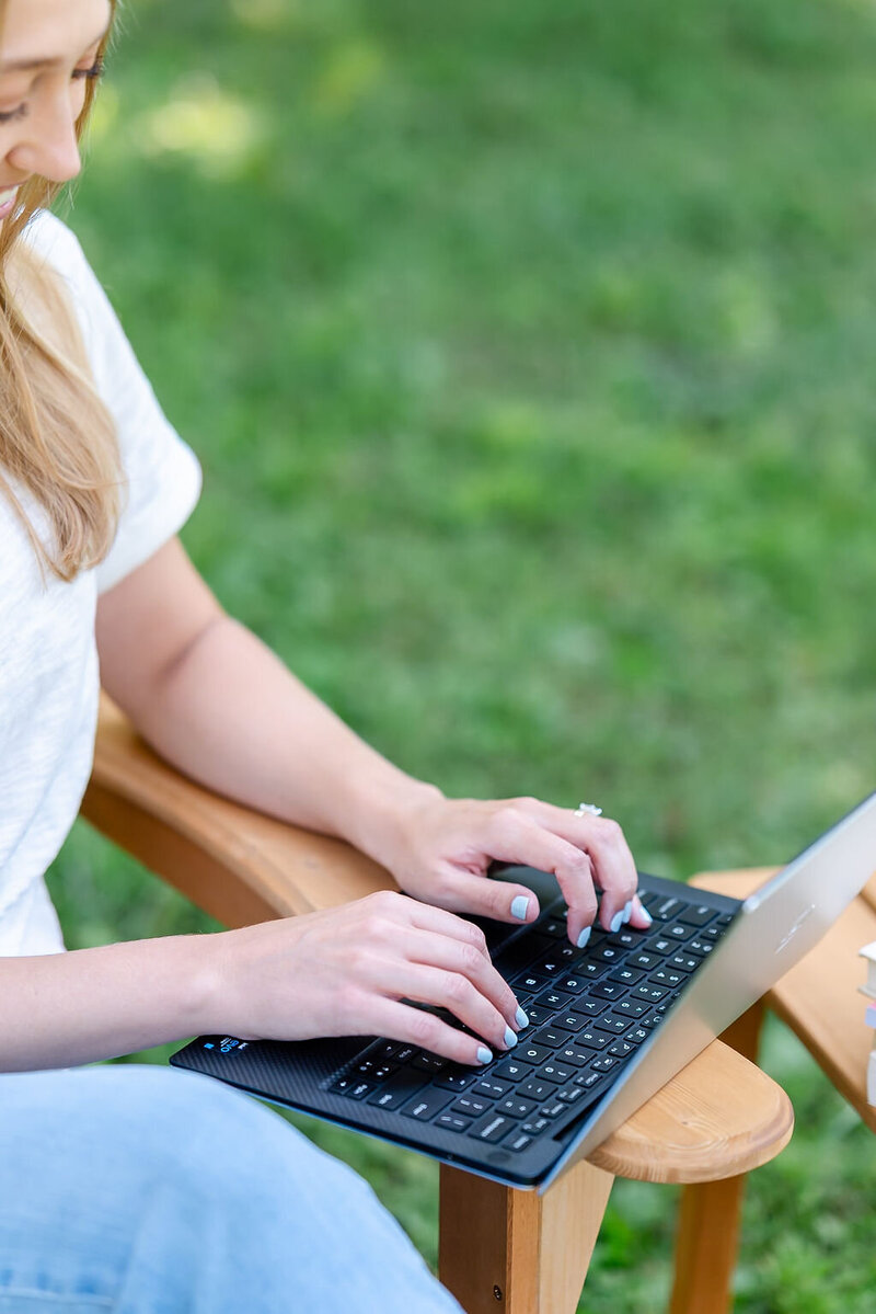 Virtual assistant types on a computer while sitting in a chair