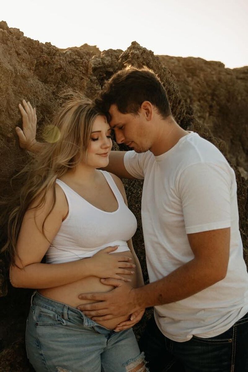 Couple in casual wear together with hands on her stomach