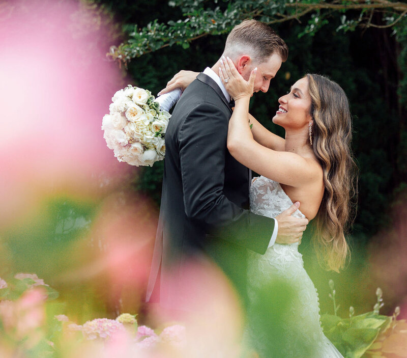 English Manor Wedding | Bride and Groom Hug Among Spring Flowers Before a Kiss | Ocean Township, New Jersey