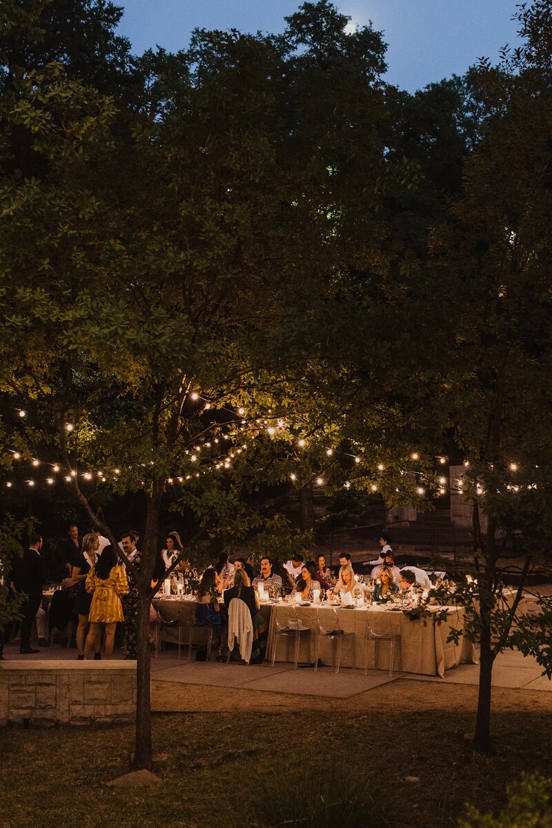 A group of people eat dinner at an event at the Umlauf Sculpture Center in Austin, Texas