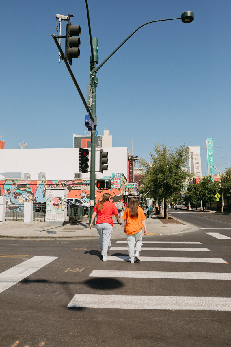 Two people walking across a city crosswalk.