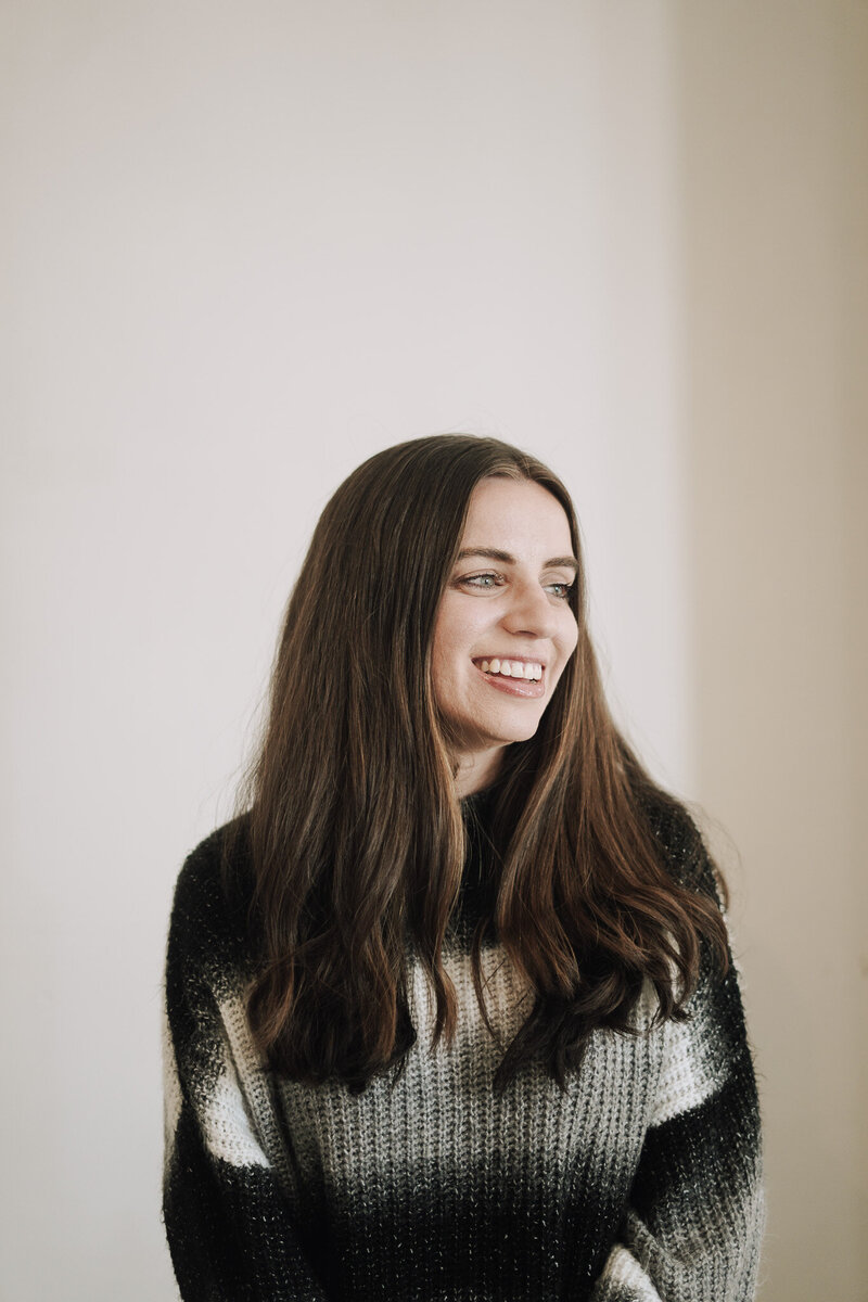 Headshot of creative director Amanda Burg wearing a cozy sweater in warm natural light