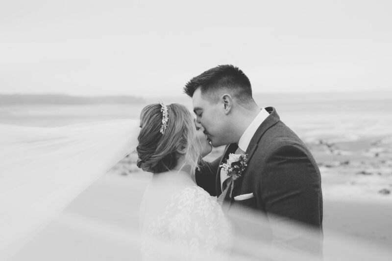 Black + white photo of couples kissing on their wedding day at Oxwich Bay Hotel