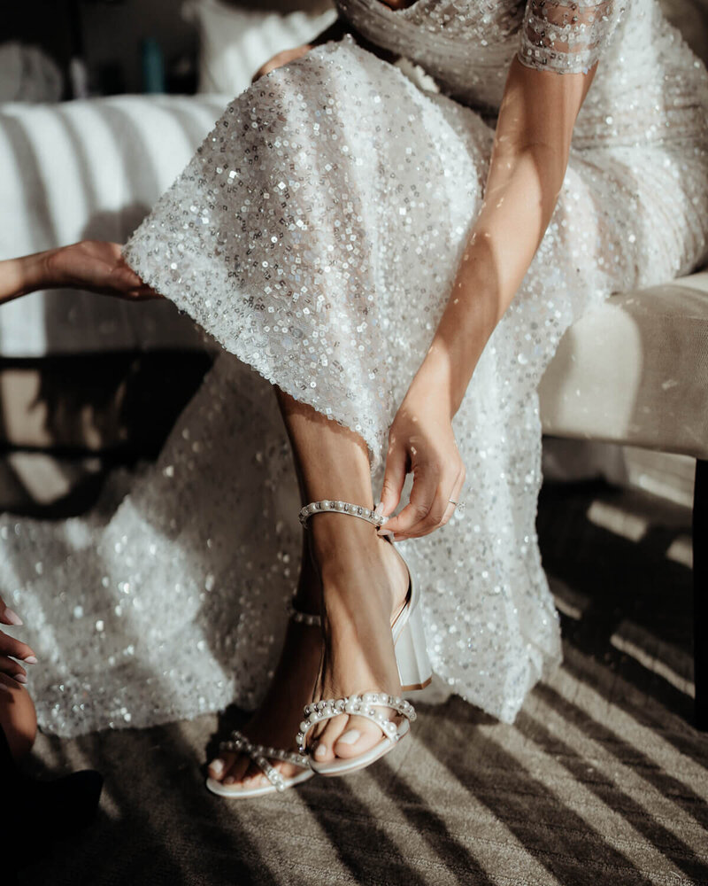 Bride putting shoes on