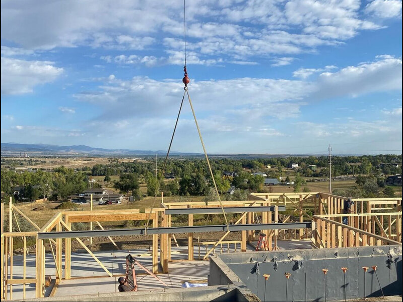 Professional crane service moving beams for residential new construction in Denver and foothills