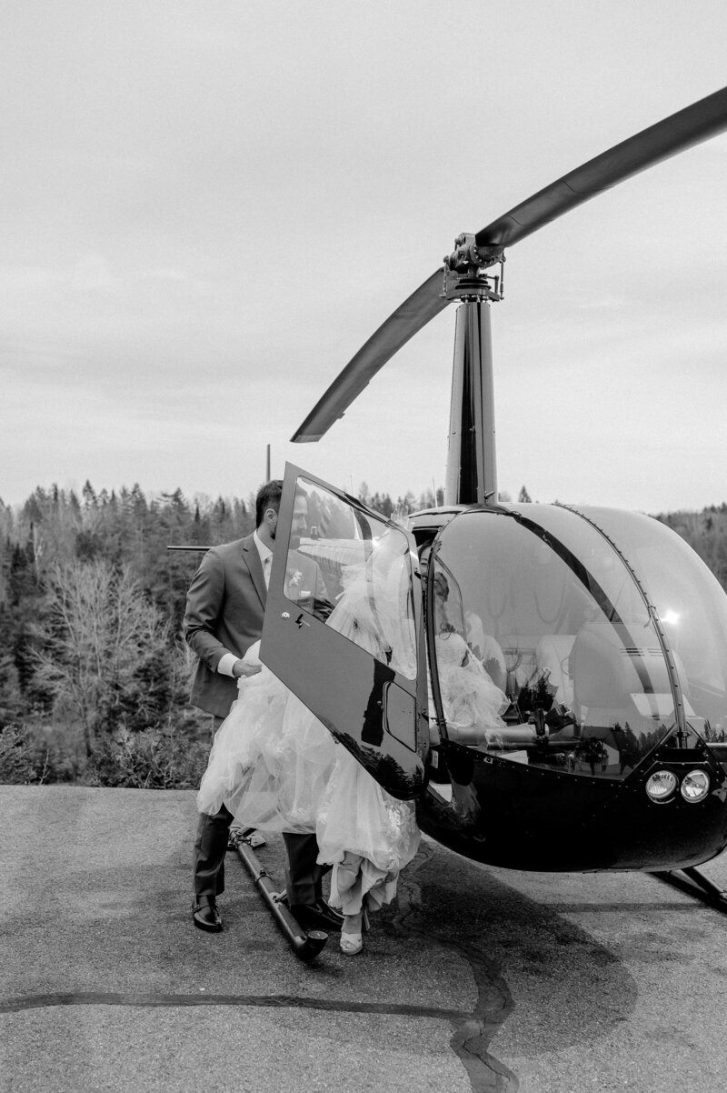 bride and groom climbing into helicopter