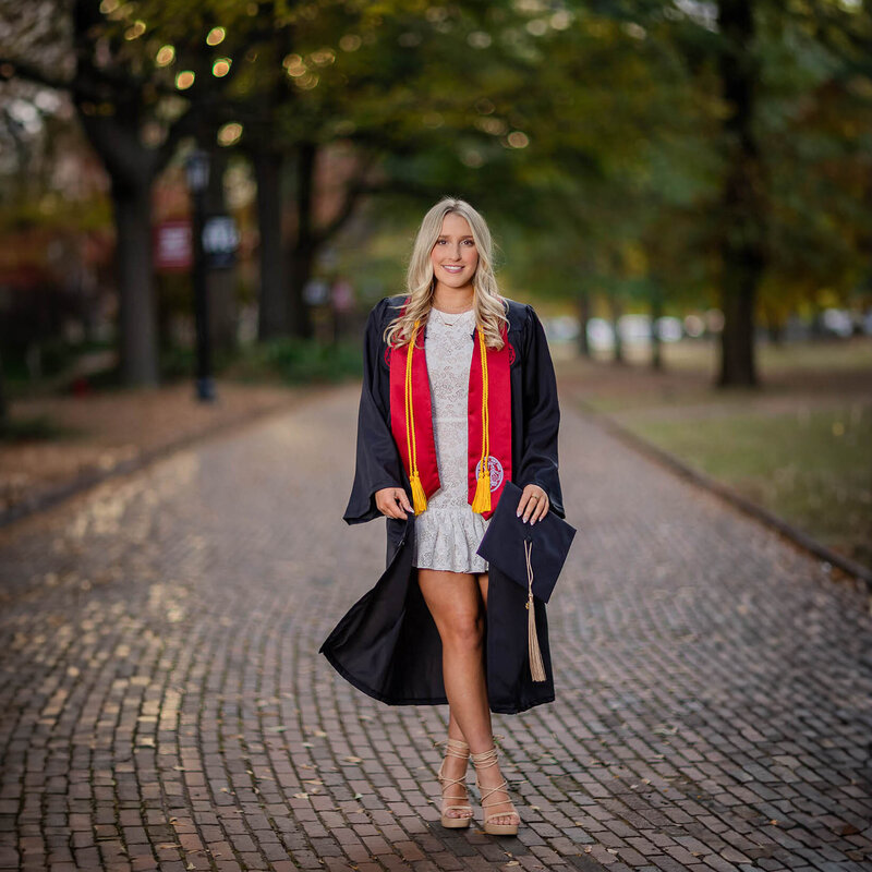A University of South Carolina student taking her senior portrait on campus at the historic horseshoe