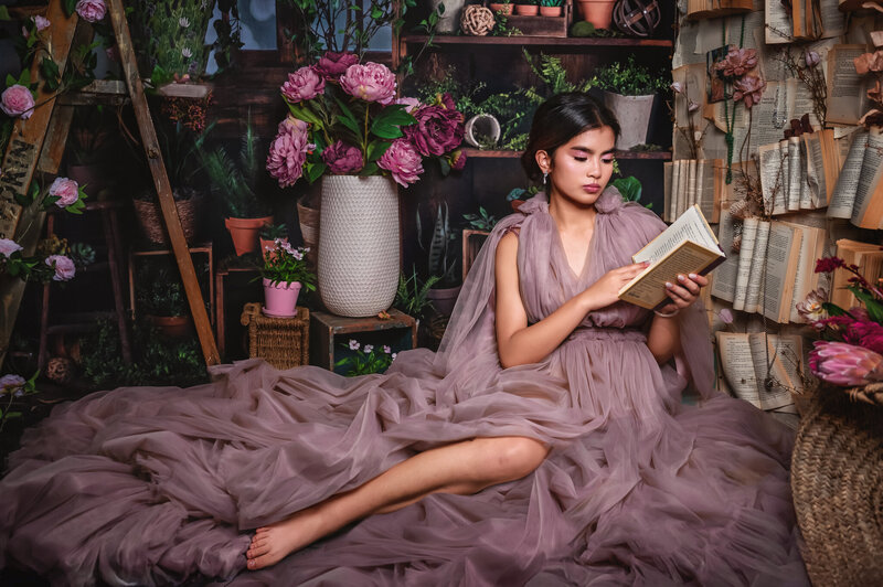 renaissance inspired , lady reading infront of book wall
