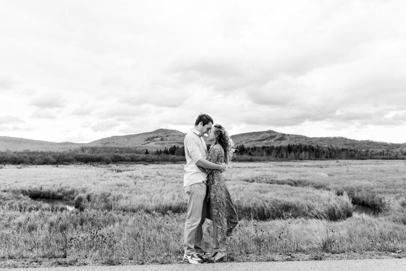 couple hugging one another with the hills and grass in the background