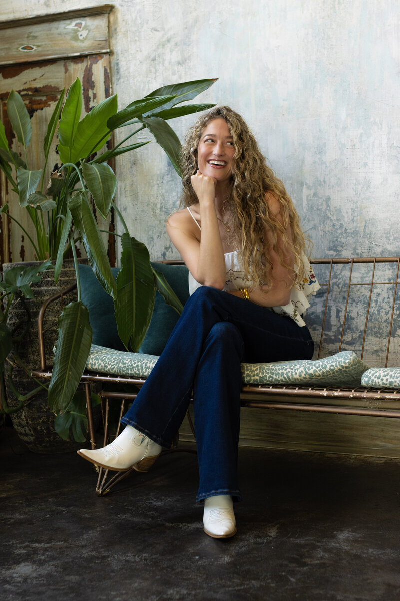 Dr. Mamie smiling and sitting casually in jeans and a white top